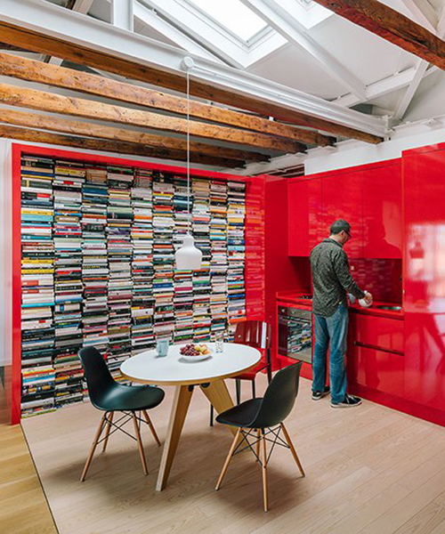 gon architects inserta un mobiliario continuo de color rojo brillante para articular un ático en madrid