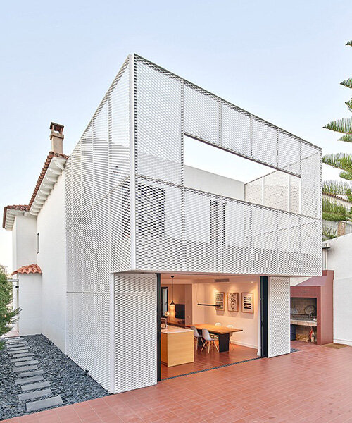 BONBA studio envuelve una ampliación residencial en barcelona con malla metálica