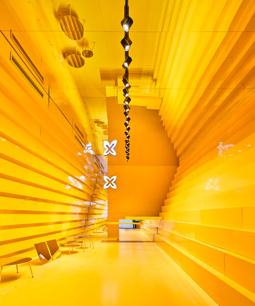 muros amarillos escalonados dan forma a una tienda de ropa en málaga, diseñada por studio animal