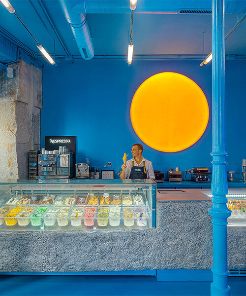 lámpara en forma de sol ilumina el interior de una heladería completamente azul en madrid, españa