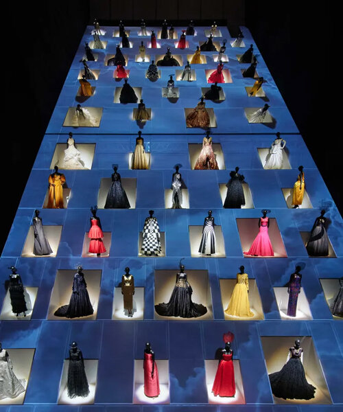 maniquíes en vestidos de gala 'escalan' por una rampa gigante en una muestra de dior diseñada por OMA en tokio