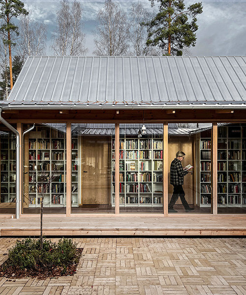 una casa diseñada por el despacho fria folket organizada en torno a una extensa biblioteca, emerge en medio de un bosque en suecia