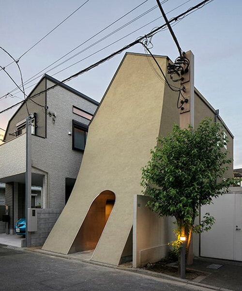 una imponente fachada introvertida alberga la casa estudio de dos niveles de un artista del manga en tokio