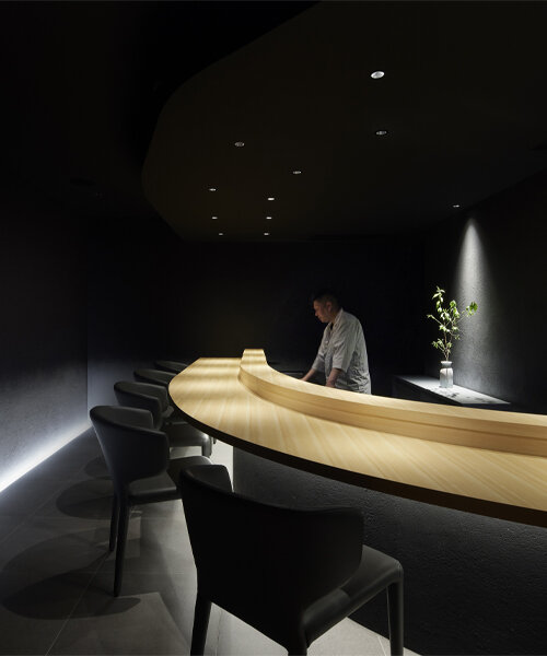 paredes de tinta negra e iluminación tenue envuelven este restaurante de sushi solo para miembros en tokio