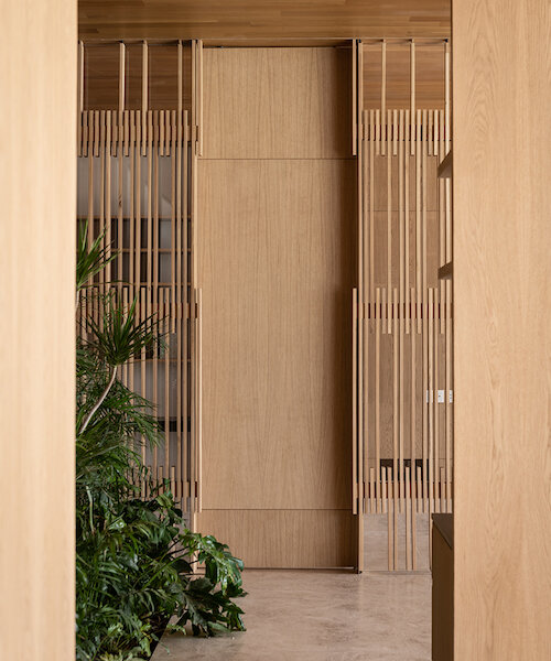 espacios que fluyen y complementan: un departamento en tonos monocromáticos y madera de roble