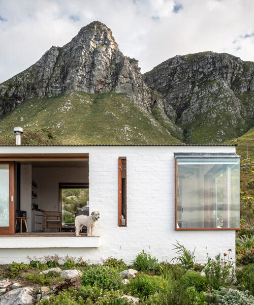 la cabaña blanca y discreta de KLG architects se posa en la ladera sudafricana