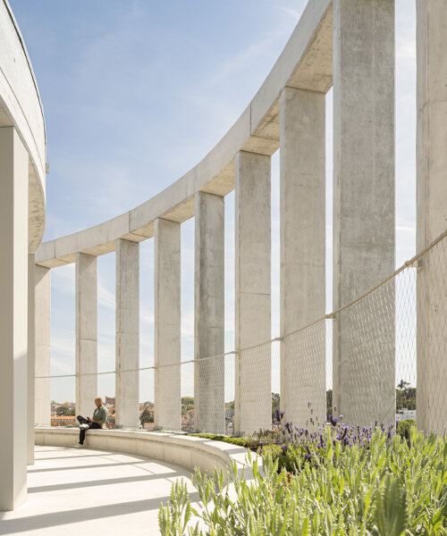 pilares de concreto envuelven una torre cilíndrica de vivienda estudiantil de OODA en oporto