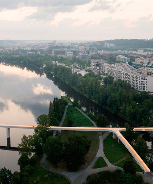 un elegante puente peatonal de concreto cruza el río moldava en praga