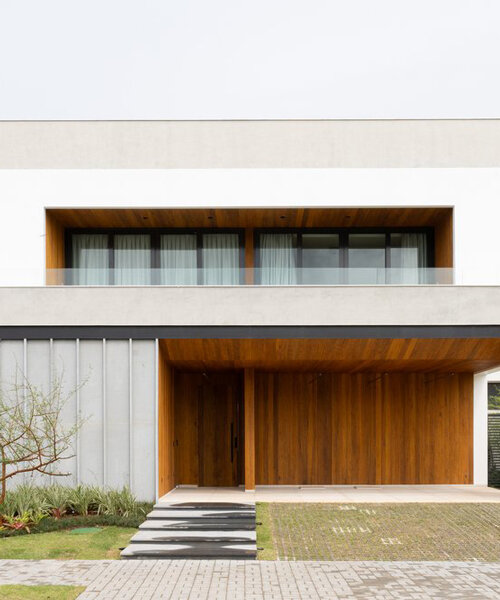 aberturas recubiertas de madera tallan una residencia monolítica de concreto en río de janeiro