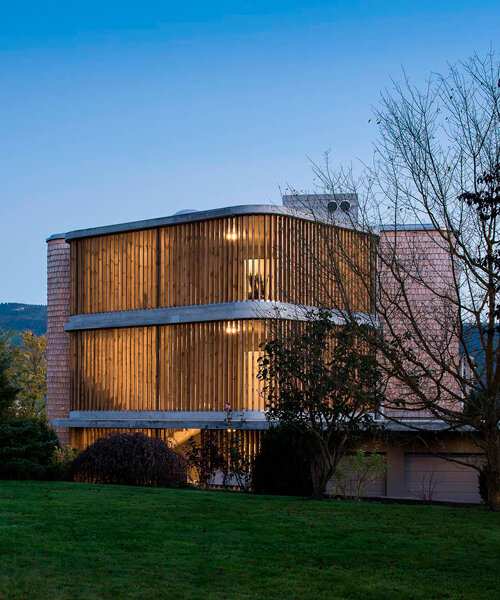 tejas de madera cortada revisten la estructura de concreto de un edificio residencial en suiza